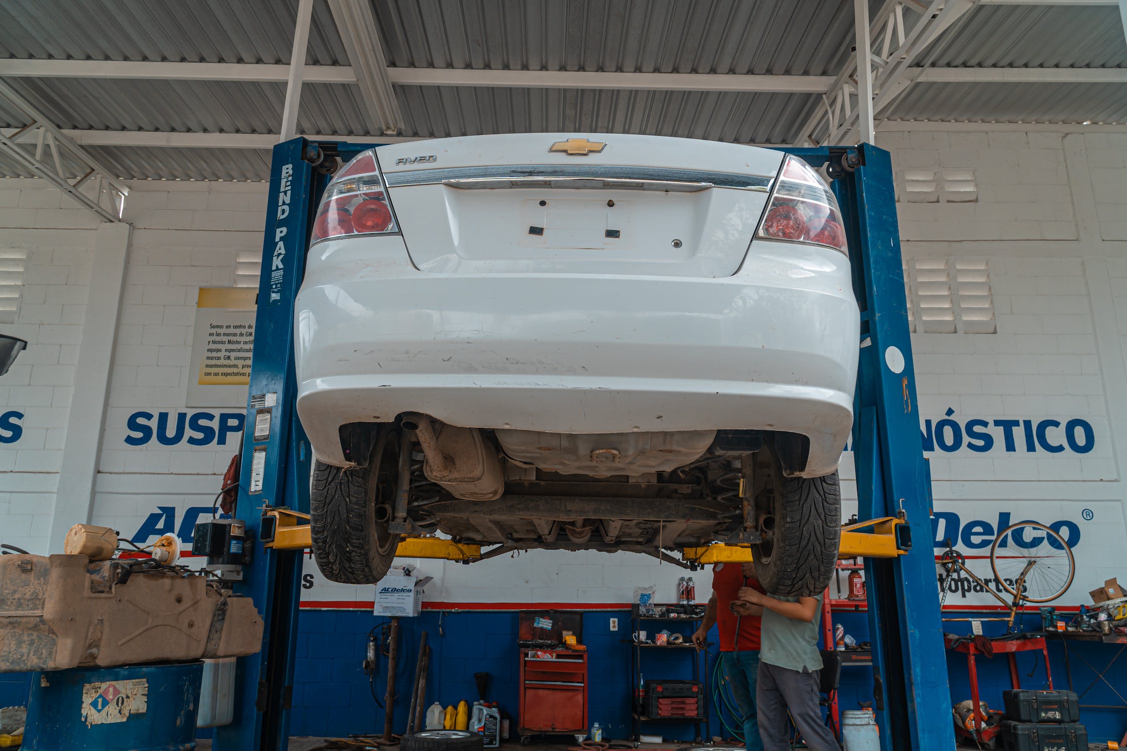 A Chevy car is lifted in an auto body shop for an oil change
